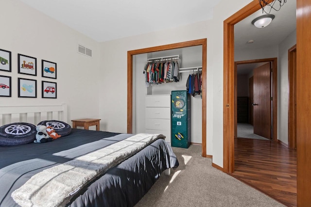 bedroom with visible vents, baseboards, a closet, and carpet flooring