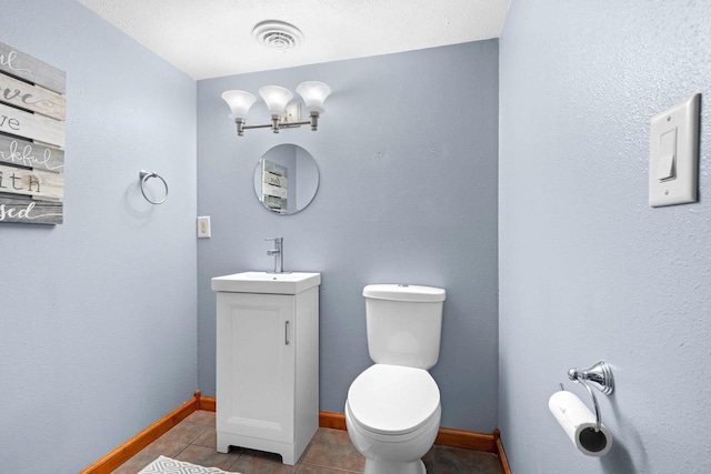 half bathroom with visible vents, toilet, tile patterned flooring, baseboards, and vanity