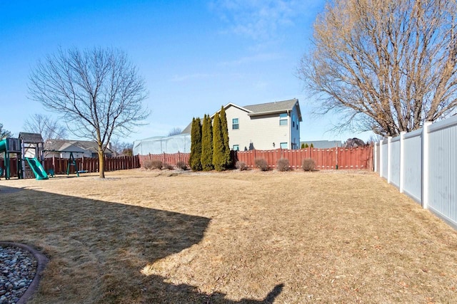 view of yard featuring a fenced backyard and a playground