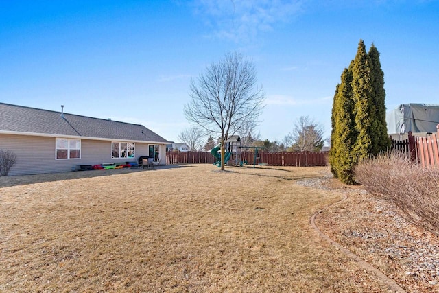 view of yard with a playground and a fenced backyard