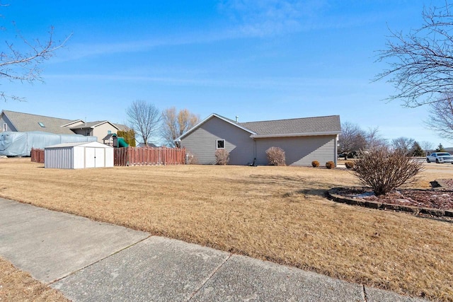 view of yard with an outbuilding, a shed, and fence