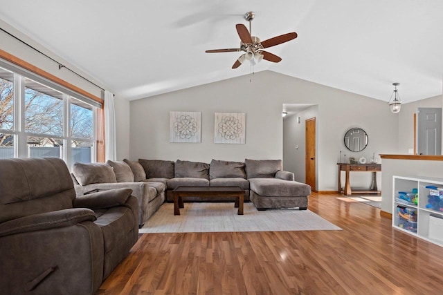 living area featuring vaulted ceiling, ceiling fan, and wood finished floors