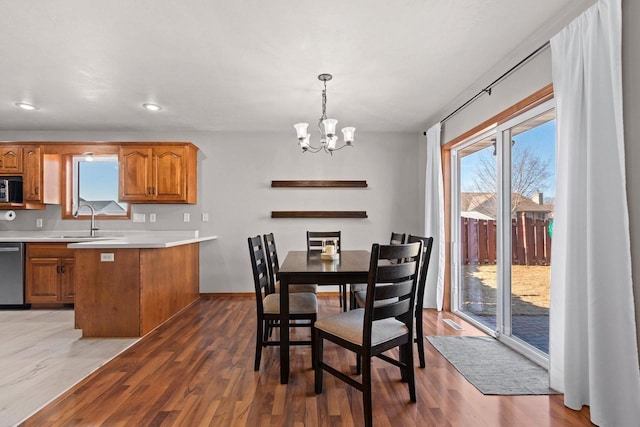 dining area featuring a chandelier, plenty of natural light, and wood finished floors