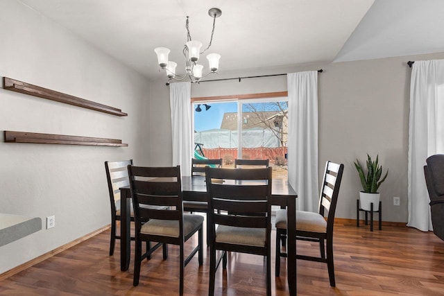 dining space featuring a notable chandelier, baseboards, and wood finished floors