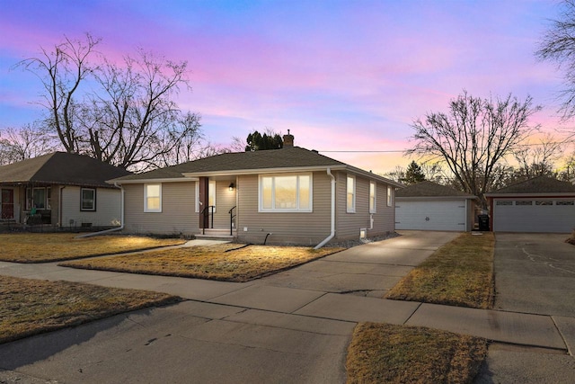 ranch-style home with an outbuilding, a chimney, and a detached garage