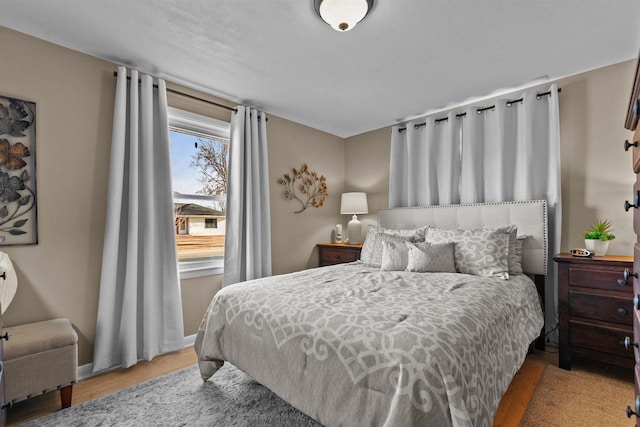 bedroom with baseboards and wood finished floors