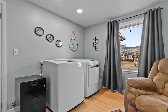 laundry room with light wood finished floors, laundry area, and washing machine and clothes dryer