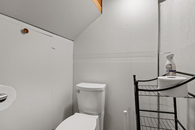 bathroom featuring lofted ceiling and toilet