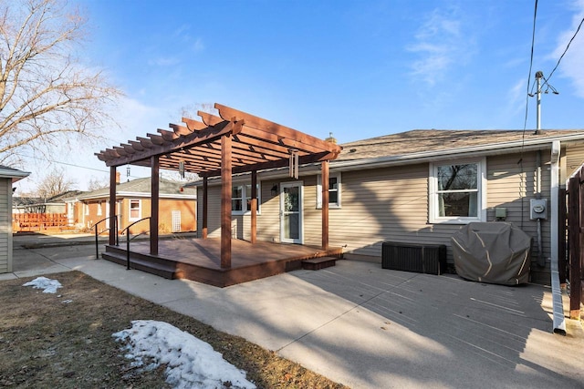 rear view of house with a wooden deck and a pergola