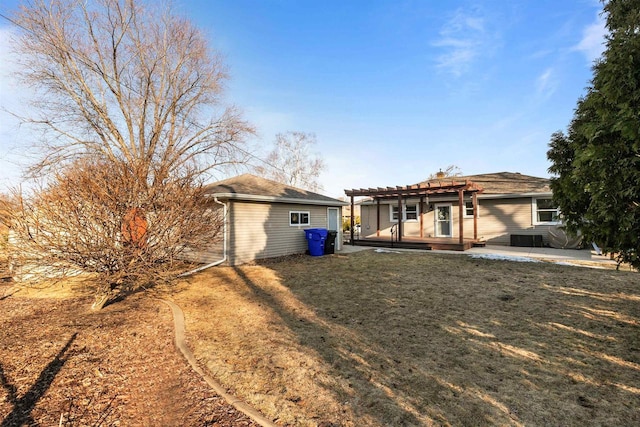 rear view of house featuring a patio area, a yard, an outdoor structure, and a pergola