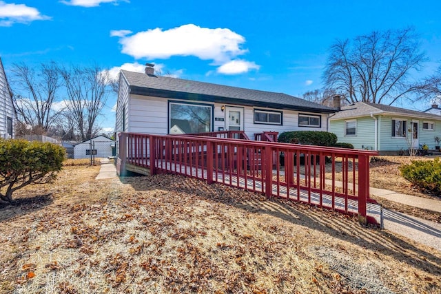 rear view of property with a chimney and a deck