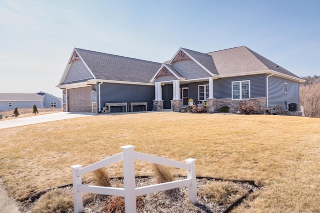 craftsman-style home with stone siding, a garage, driveway, and a front yard