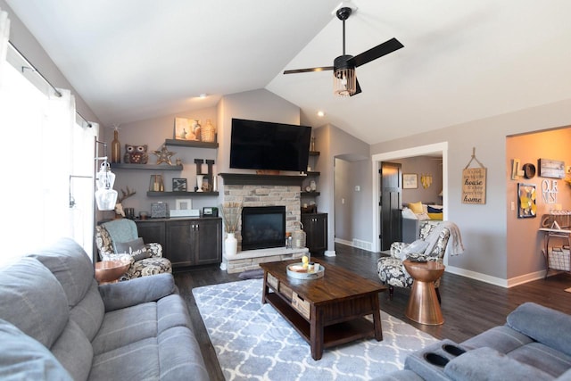 living room featuring ceiling fan, a fireplace, dark wood-type flooring, and lofted ceiling