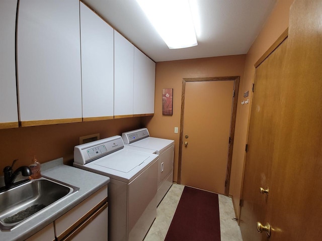 laundry room with cabinet space, washer and dryer, and a sink