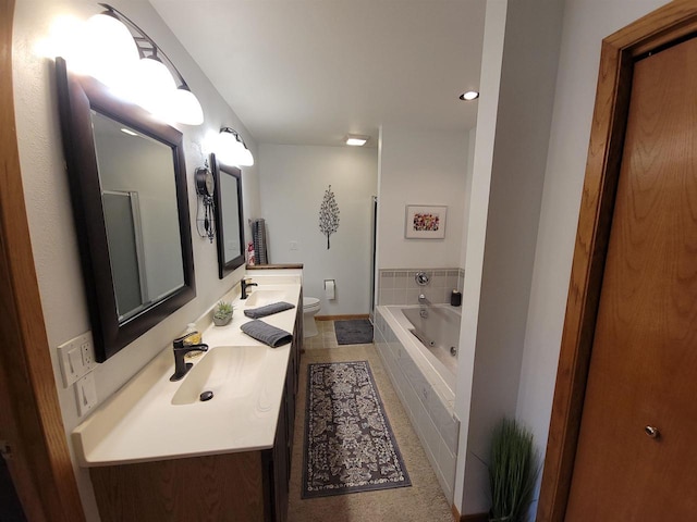 bathroom featuring a sink, tiled tub, toilet, and double vanity