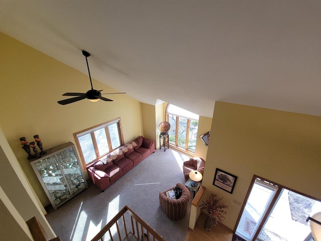 living room featuring carpet flooring, a ceiling fan, and high vaulted ceiling