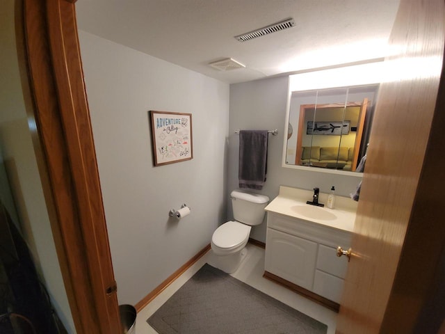 bathroom with vanity, toilet, baseboards, and visible vents