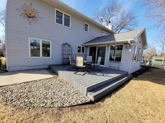 rear view of house featuring a deck and a chimney