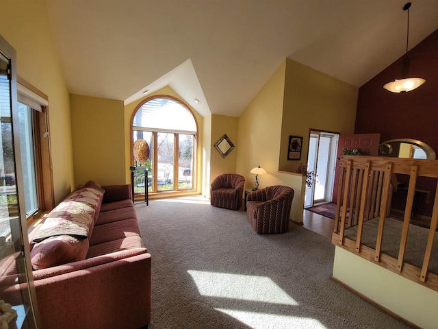 carpeted living area with high vaulted ceiling