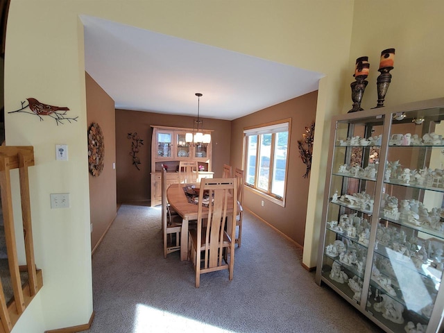 dining space featuring a chandelier, baseboards, and carpet