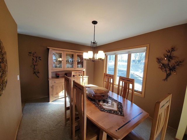 dining room with an inviting chandelier, baseboards, and carpet