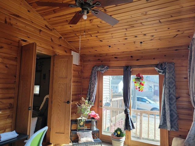 unfurnished dining area with visible vents, wooden walls, lofted ceiling, wood ceiling, and ceiling fan