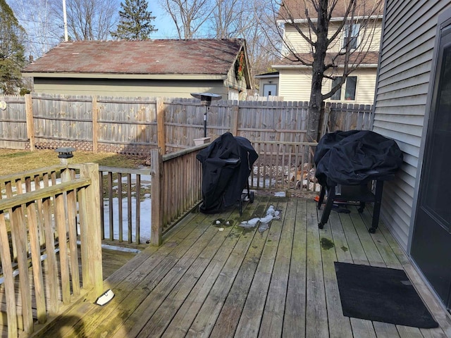 wooden terrace with a fenced backyard and a grill