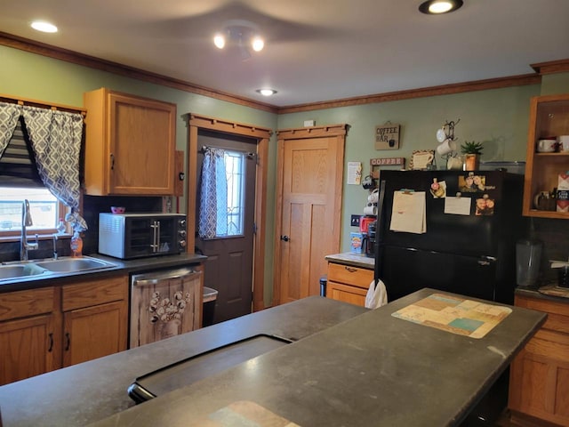 kitchen with dark countertops, ornamental molding, brown cabinets, black appliances, and a sink