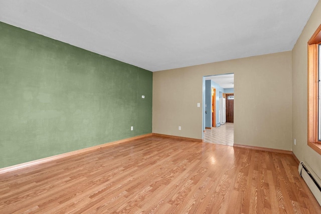 spare room with light wood-style floors, baseboards, and baseboard heating