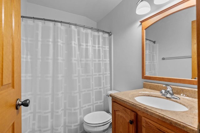 bathroom featuring curtained shower, toilet, and vanity