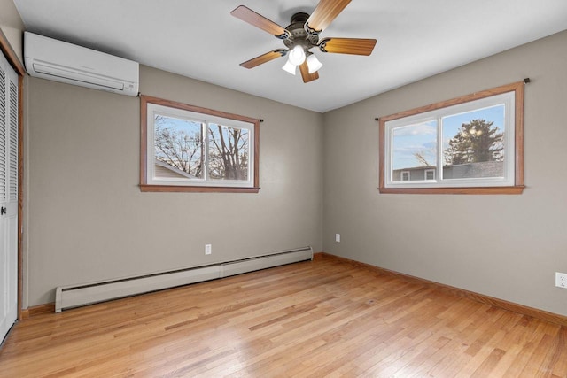 unfurnished bedroom featuring baseboards, a wall mounted AC, light wood-style flooring, a closet, and a baseboard heating unit