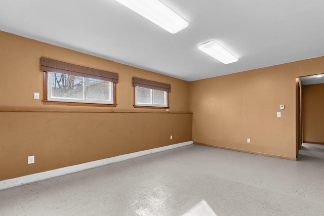 unfurnished room with baseboards