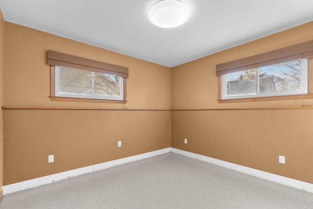 unfurnished room featuring a healthy amount of sunlight and baseboards