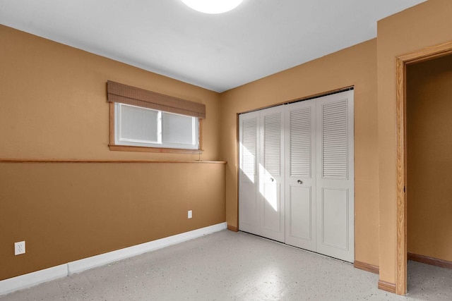 unfurnished bedroom featuring baseboards and a closet