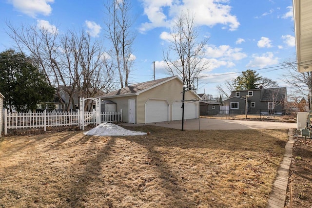 exterior space featuring a detached garage, an outdoor structure, and fence