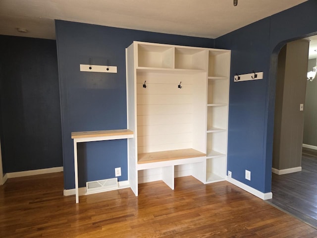 mudroom with visible vents, arched walkways, baseboards, and wood finished floors