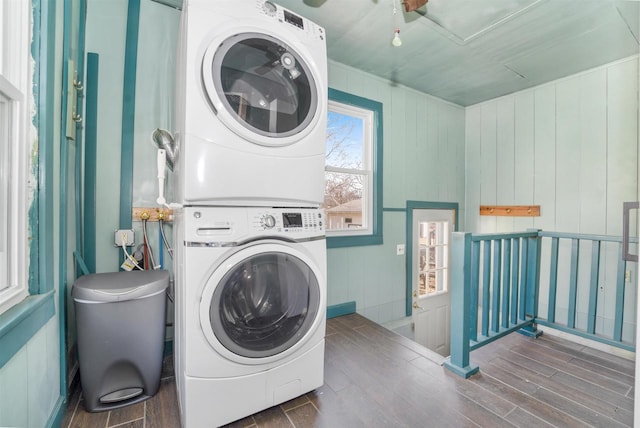 laundry area with laundry area, stacked washing maching and dryer, and wood finish floors