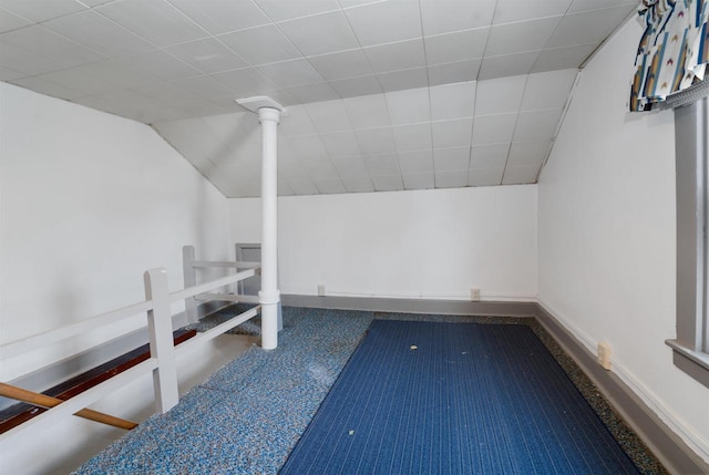 additional living space featuring baseboards and vaulted ceiling