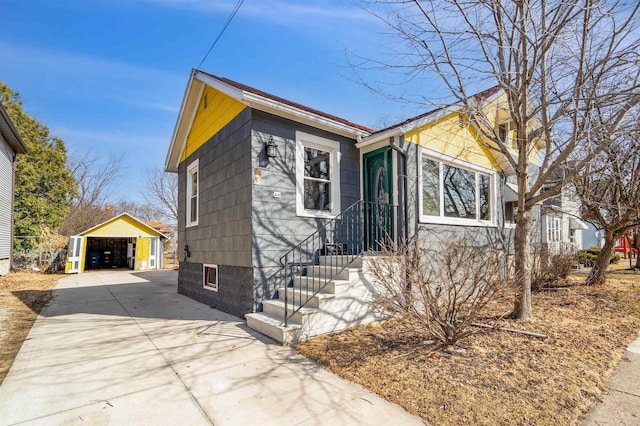 view of front of house featuring a detached garage and an outdoor structure