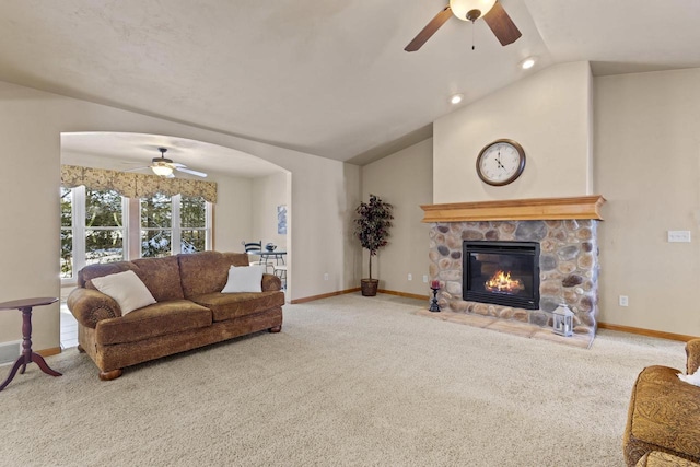 carpeted living area with baseboards, arched walkways, lofted ceiling, and a fireplace