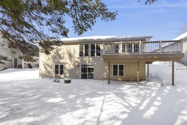 snow covered back of property featuring a wooden deck