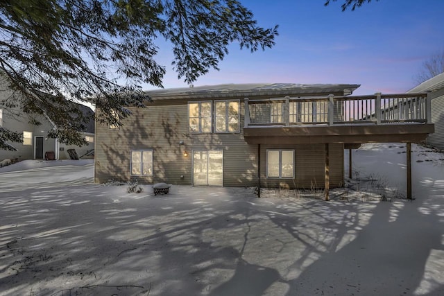 back of property at dusk with a wooden deck