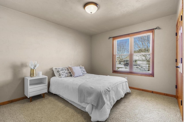 bedroom with light carpet and baseboards