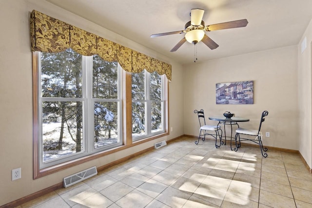 interior space featuring a ceiling fan, light tile patterned floors, baseboards, and visible vents