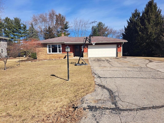 single story home featuring driveway, an attached garage, a chimney, a front lawn, and brick siding