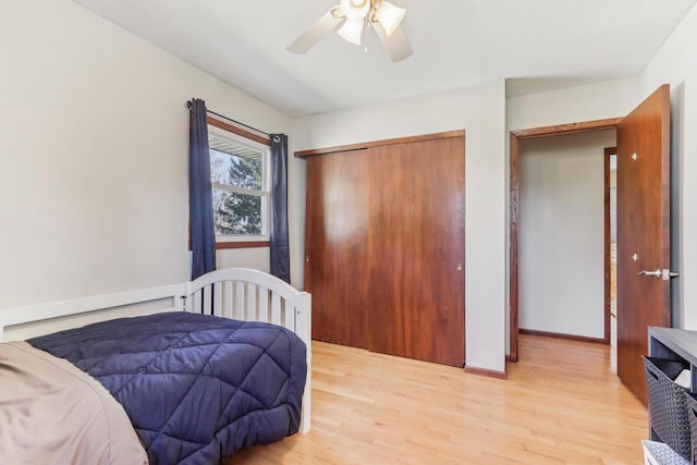 bedroom with a closet, light wood-style flooring, baseboards, and a ceiling fan