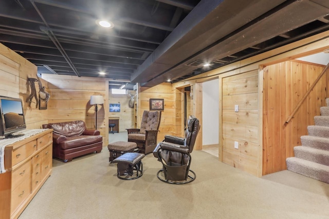 carpeted living room featuring stairway and wooden walls