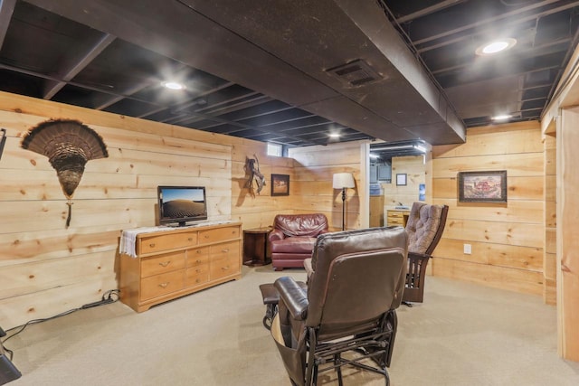 carpeted living room featuring visible vents and wood walls