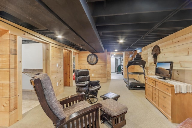 finished basement featuring light colored carpet and wooden walls