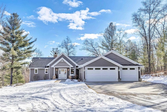 view of front of house with a chimney, an attached garage, and concrete driveway